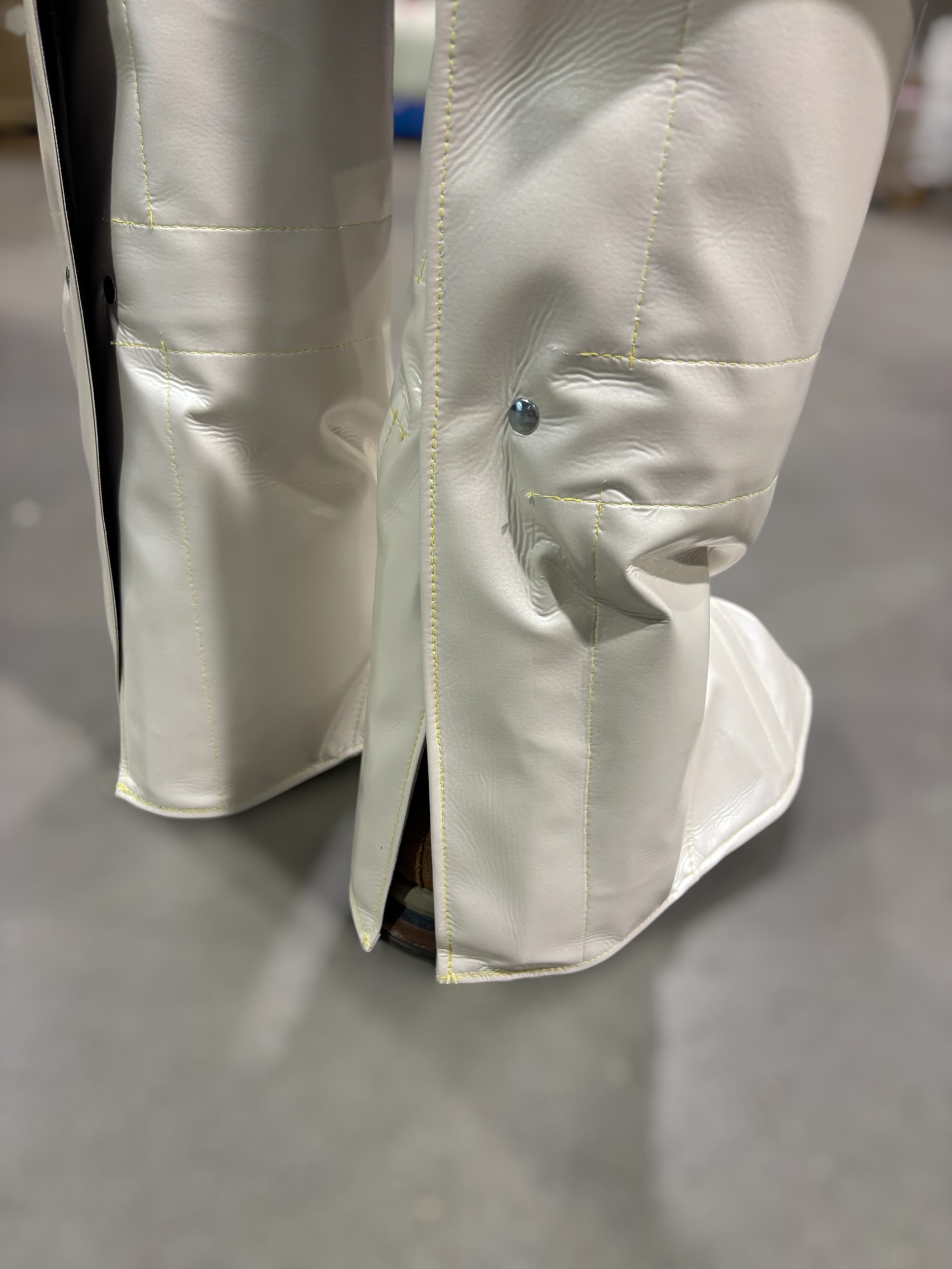 Beine mit weißen, glänzenden Laserschutzgamaschen, die über den Füßen getragen werden