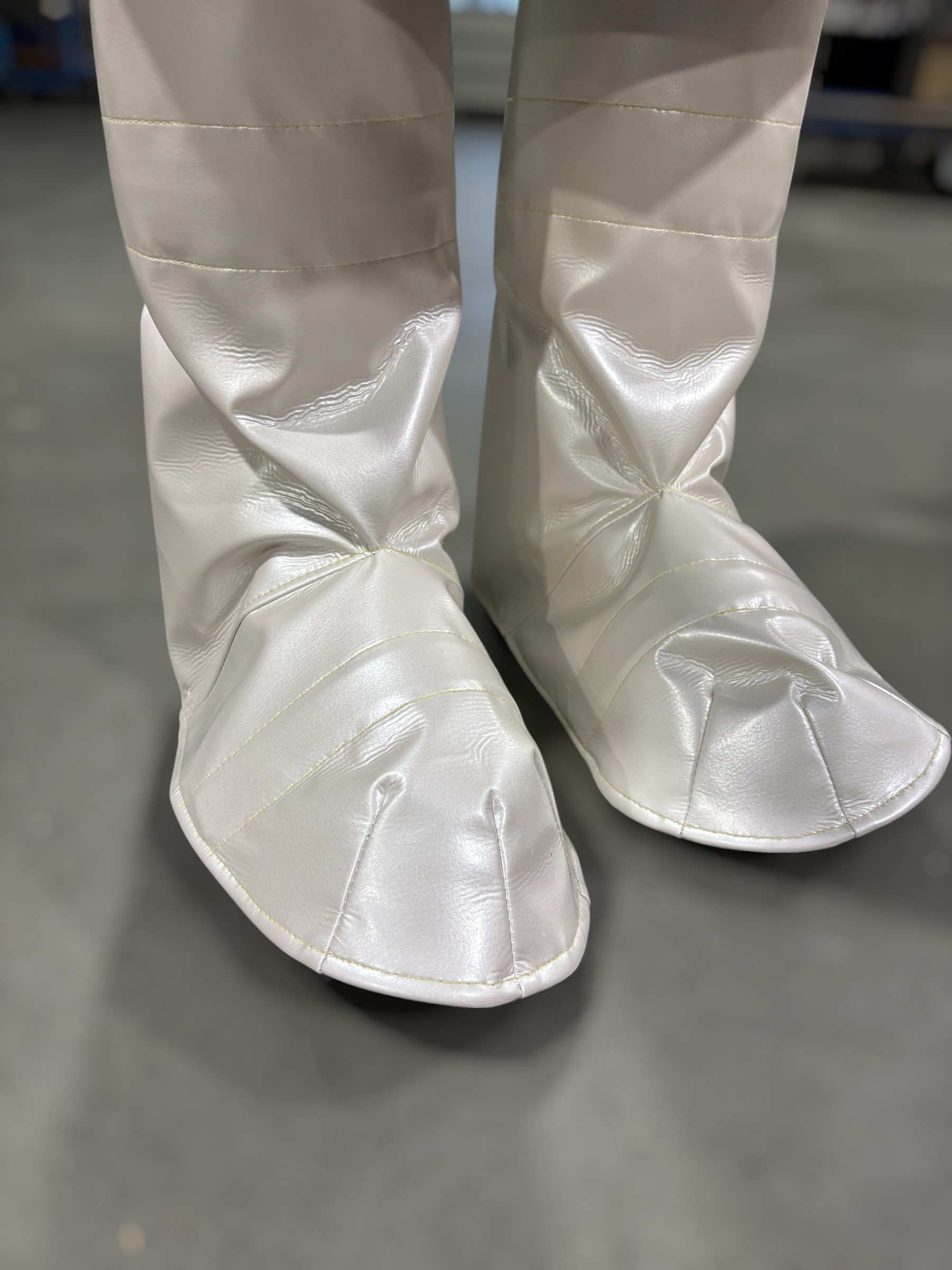 Beine mit weißen, glänzenden Laserschutzgamaschen, die über den Füßen getragen werden